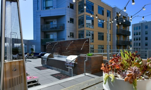 grills and landscaping on a lounge rooftop area