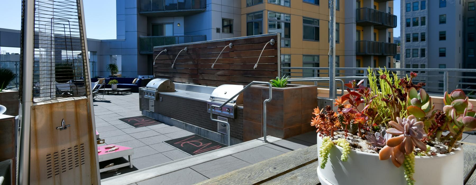 grills and landscaping on a lounge rooftop area